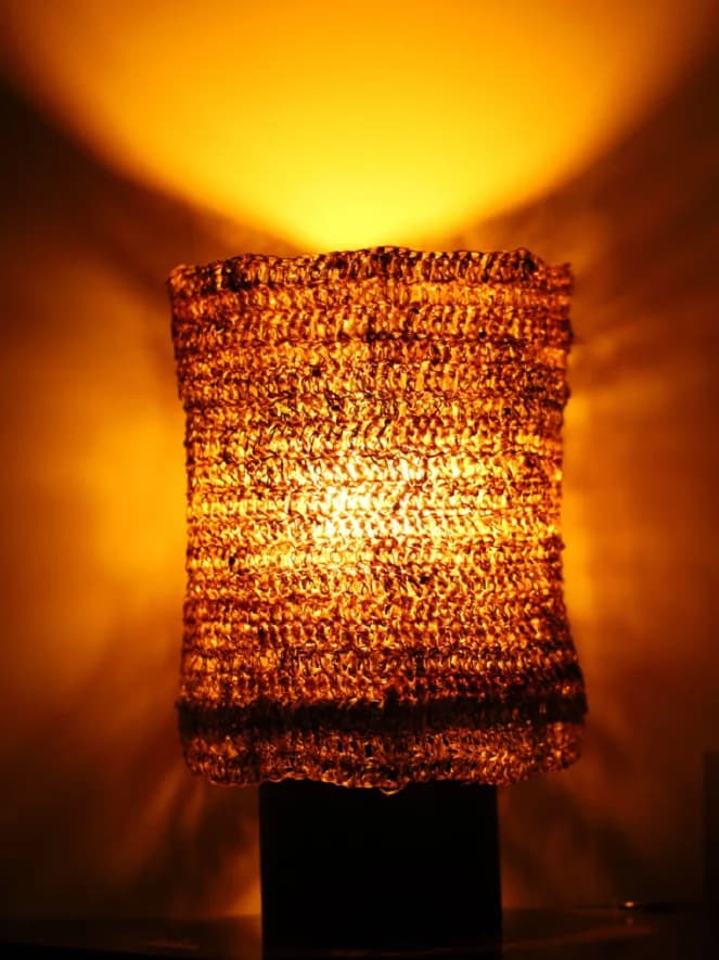 Luminária de mesa com trama orgânica iluminada