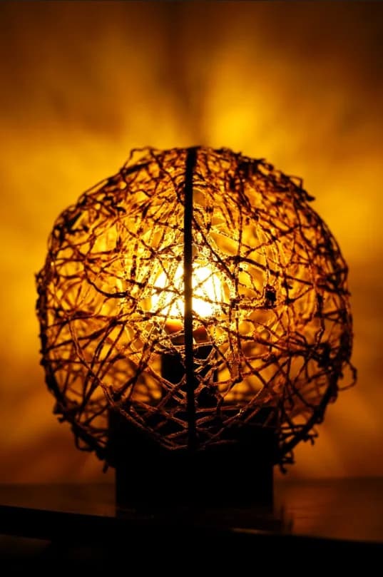 Luminária esférica de fibras tramadas acesa